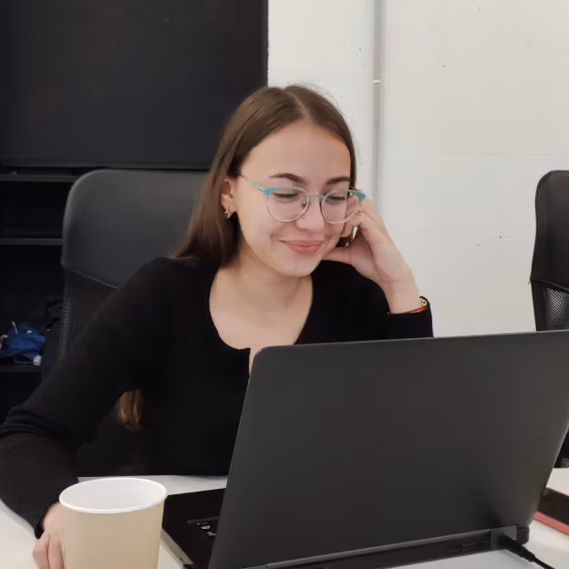 Flexum team member smiling at a laptop