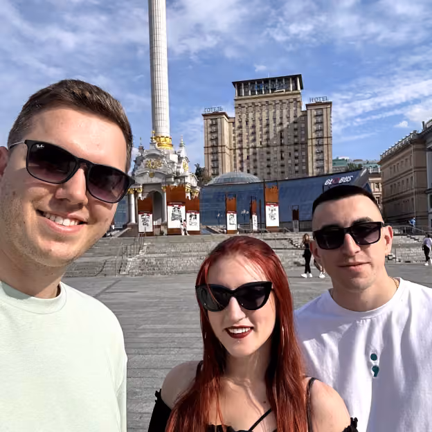 Three team members taking a selfie on Independence Square in Kyiv