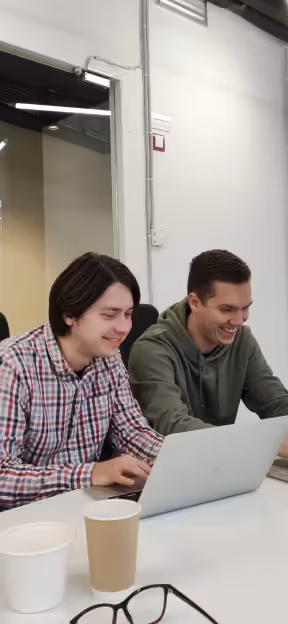 Two team members working together on a laptop